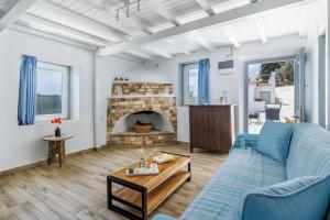a living room with a blue couch and a fireplace at The Mountain Majesty in Skopelos Town +28 photos