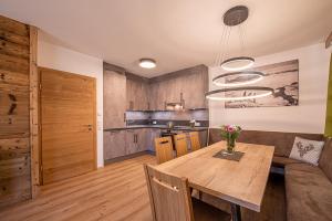 uma cozinha e sala de jantar com uma mesa de madeira em AppartMO - Zillertal Arena, Hohe Tauern, Salzburgerland, Krimml, Hochkrimml em Krimml