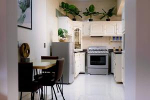 a kitchen with white cabinets and a table with chairs at Casa Amma - Chita in Matehuala