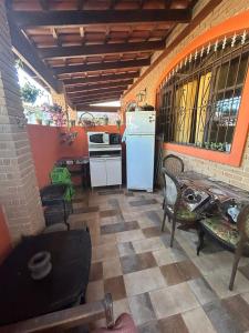 eine Küche mit einem Kühlschrank sowie einem Tisch und Stühlen in der Unterkunft Hospedaria Canto Ubuntu Kitnet in Caraguatatuba