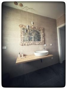 a bathroom with a sink and a mirror on the wall at Appartamento Miro' Fine Living in Alghero