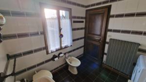 a bathroom with a toilet and a window at Casetta immersa nella natura in Riolunato +32 photos