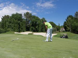 een man speelt golf op een golfbaan bij Lou Romarin in Nans-les-Pins