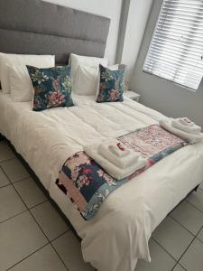 a white bed with pillows and towels on it at The Silhouette in Paarl