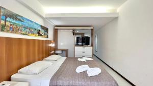 une chambre avec un grand lit avec des serviettes dessus dans l'établissement Apartamento Beira Mar centro Pipa com Piscina vista mar completo, à Pipa