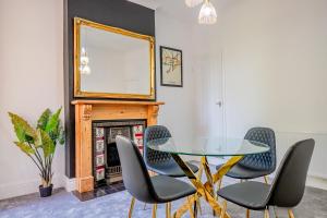 Un comedor con una mesa de cristal y sillas. en Host & Stay - Somerset Road House, en Birmingham
