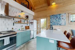 a kitchen with blue cabinets and a white refrigerator at Hytta Hyggelig in Tabernash +23 photos
