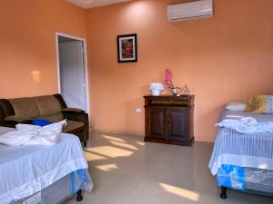 a hotel room with two beds and a couch at Hotel el Paredon in El Paredón Buena Vista