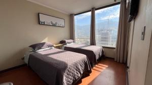 two beds in a room with a large window at Apartamentos City Centro Manuel Montt in Santiago +221 photos