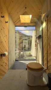 Habitación con ventana y baño con aseo. en Paradise Ranch Inn - Liberated Tent, en Three Rivers
