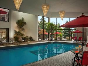 a swimming pool in a hotel with tables and umbrellas at White Oaks Conference & Resort Spa in Niagara on the Lake