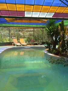 una piscina con techo de colores brillantes y un patio en Hotel Bellavista, en Huaran