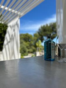una botella azul sentada sobre una mesa con gafas en Petra Maris B&B en Peschici