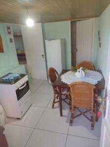 a kitchen with a table and chairs and a stove at Suíte Araucária in Campos do Jordão