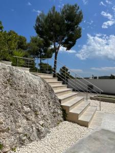 un conjunto de escaleras junto a una pared de piedra con un árbol en Petra Maris B&B en Peschici