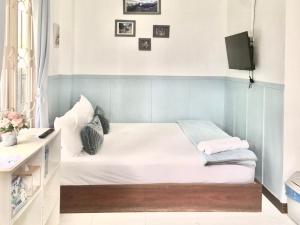 a small bedroom with a bed and a tv at Thirty Tree Garden House in Chumphon