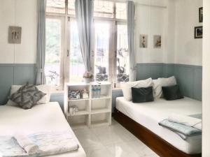 a bedroom with two beds and a window at Thirty Tree Garden House in Chumphon
