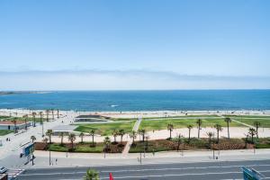 卡萨布兰卡Atlantic View Appart'Hotel的享有棕榈树海滩和大海的景色