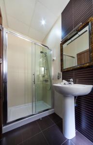 a bathroom with a sink and a glass shower at Port View Guesthouse in Marsaxlokk