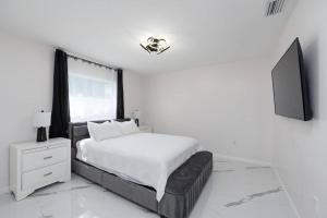 ein Schlafzimmer mit einem Bett und einem Flachbildfernseher in der Unterkunft Luxury Style townhome with Pool - 1 Miles to Bucs Stadium in Tampa