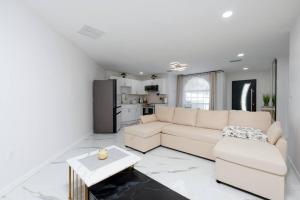 ein weißes Wohnzimmer mit einer Couch und einem Tisch in der Unterkunft Luxury Style townhome with Pool - 1 Miles to Bucs Stadium in Tampa