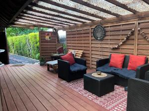 eine Terrasse mit 2 Sofas und einer Holzterrasse in der Unterkunft Faaora Lodge, little paradise in Haapiti