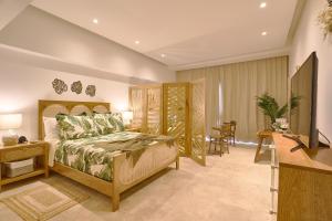 a bedroom with a bed and a desk and a television at Beautiful Modern Studio At Cap Cana, Punta Cana in Punta Cana