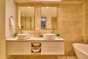 two sinks in a bathroom with a tub and a mirror at Beautiful Modern Studio At Cap Cana, Punta Cana in Punta Cana +20 photos