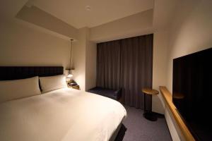 東京にあるホテルリソルステイ秋葉原のベッドとテレビが備わるホテルルームです。
