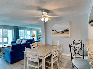- un salon avec une table à manger et un canapé bleu dans l'établissement Sea Oats #409, à Fort Walton Beach