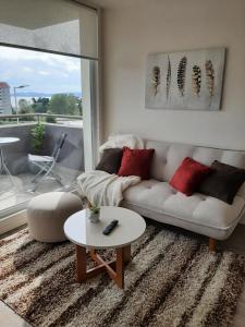 sala de estar con sofá y mesa en Departamento con vista al mar en Puerto Montt, en Puerto Montt