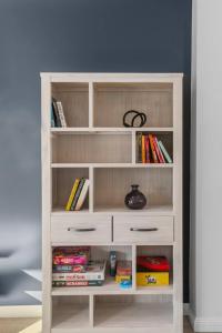 a white book shelf filled with books at Stadium Escape - A Contemporary Beachside Retreat in Wollongong