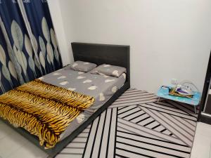 - une chambre avec un lit doté d'une couverture noire et jaune dans l'établissement Homestay Millazzz Apparment Ipoh, à Kampong Duson Gilap