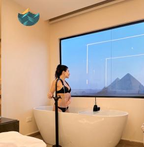 een vrouw in een bad in een badkamer bij Crowne Pyramids view inn in Caïro