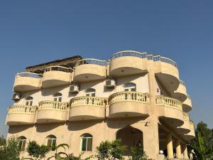 a building with balconies on the side of it at Sunset Guesthouse Abusir in Cairo