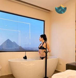 uma mulher de pé numa banheira na casa de banho em Crowne Pyramids view inn em Cairo