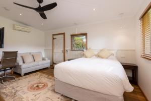 a bedroom with a bed and a ceiling fan at Bon Accord Luxury Accommodation in Sale