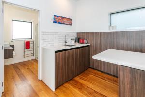 a kitchen with wooden cabinets and a white counter top at Cathedral cove and Sunrise in Hahei