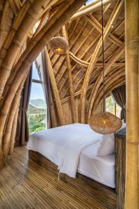 ein Schlafzimmer mit einem Bett in einer Bambusdecke in der Unterkunft Villa Grazia - Anima Eco Lodge -Ville Lussuose con Piscina Vista Mare in Selong Belanak