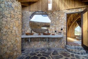 ein Badezimmer aus Stein mit einer großen Schüssel an der Wand in der Unterkunft Villa Grazia - Anima Eco Lodge -Ville Lussuose con Piscina Vista Mare in Selong Belanak