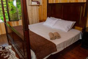 a bedroom with a bed with two towels on it at Cabaña Ave Del Paraiso in Cartago