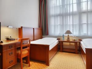 a bedroom with a bed and a desk at Hotel Bellmoor im Dammtorpalais in Hamburg