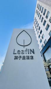 a sign for a leahin office in front of a building at LeafIN Hotel Beijing Minzuyuan l Bird's Nest in Beijing