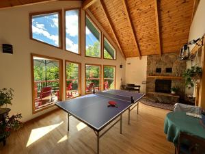 eine Tischtennisplatte in einem Wohnzimmer mit Fenstern in der Unterkunft The Burgundy Dream Bed And Breakfast in Fall River