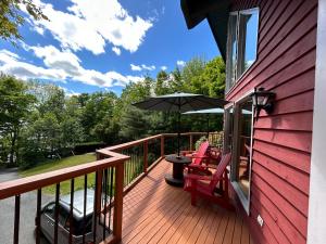 a deck with a table and chairs and an umbrella at The Burgundy Dream Bed And Breakfast in Fall River