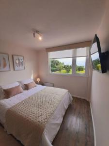 Un dormitorio con una cama grande y una ventana en Departamento con vista al mar en Puerto Montt, en Puerto Montt