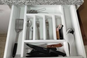 a white drawer with utensils in it at Departamento con vista al mar in Jaramijó