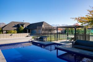a house with a swimming pool with blue water at Beacon Point Retreat by Sotheby's Luxury Rental Homes in Wanaka