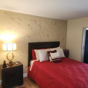 a bedroom with a bed with a red bedspread at Jubilee Gardens Freeport in Freeport