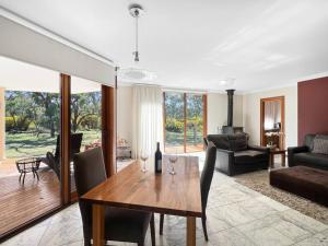 un soggiorno con tavolo e sedie in legno di Aurora Cottages - Six Seasons a Pomonal